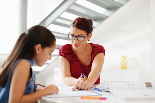 Education With Mom Helping Daughter Doing School Homework At Home